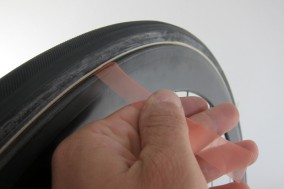Nun ziehen wir vorsichtig die Schutzfolie zwischen dem Klebeband und dem Reifen heraus und achten darauf, dass es nicht einreißt.